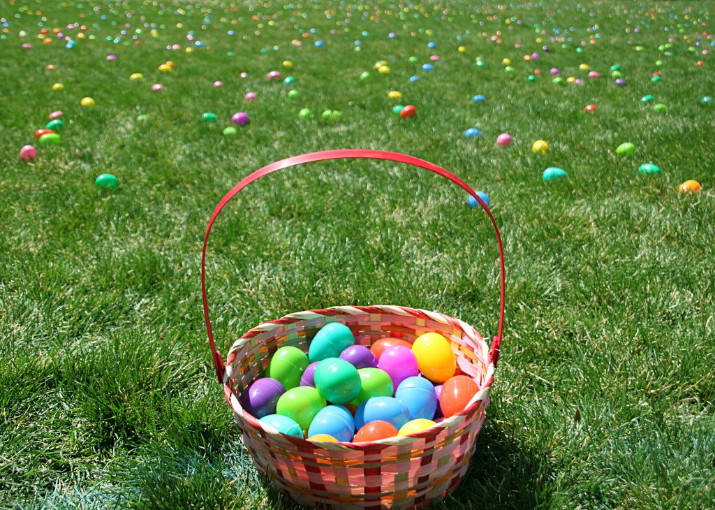 Easter egg basket on field covered with eggs