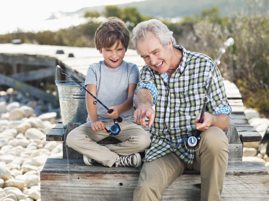 grandfather and grandson fishing on a pier together making new memories